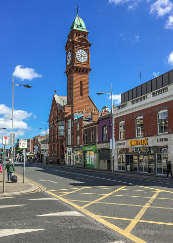 DUBLIN, LEINSTER, IRELAND - MAY 13, 2018: Rathmines College red brick building with prominent tower clock under a blue sky in a sunny spring day. This commercial area is lively and full of shops.