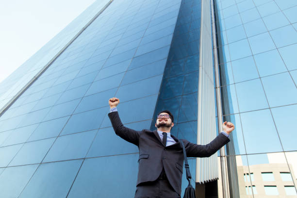 istock Ecstatic young business man with arms in air 1064175316