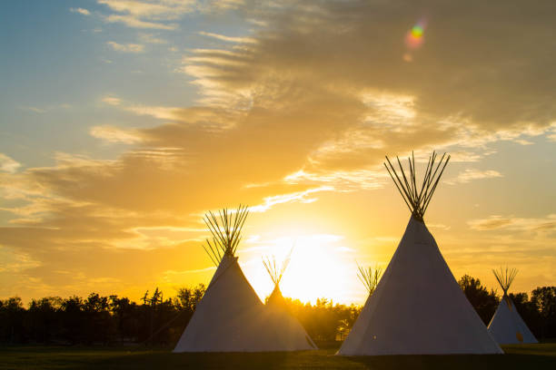 indianer tipi in der prärie bei sonnenuntergang - teepee stock-fotos und bilder