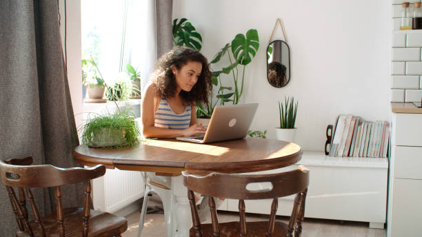 istock Charming young woman typing on laptop computer at home. 1064178128