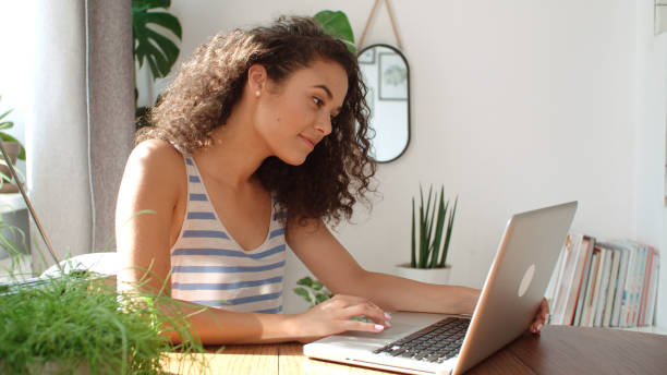 istock Charming young woman typing on laptop computer at home. 1064178132