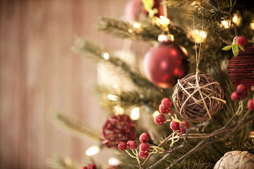 Christmas tree with eco friendly decorations, ornaments and gifts on an old wood background