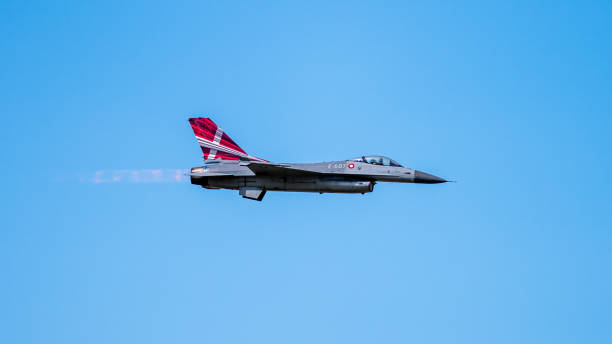 датский f-16 fighting falcon в скоростном действии в профиль с ясным голубым небом в фоновом р�ежиме - general dynamics f 16 falcon стоковые фото и изображения