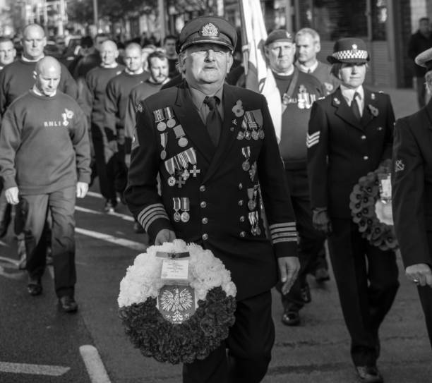 sonntag remembrance day parade, menschen und veteranen marschieren in die jährliche parade, clacton auf meer, essex - royal marines stock-fotos und bilder