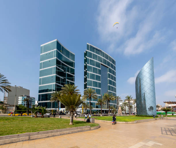View at the Marriott hotel towers in the Miraflores district in Lima, Peru, during a hot day in the spring. People walking in the park in front of the hotel.