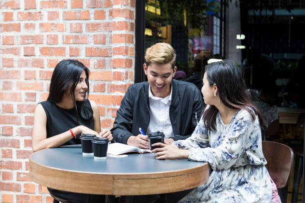 istock Series of three people discussing over coffee in casual setting 1064193274