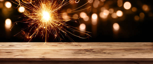 istock Christmas background with wooden table and sparkler 1064195286