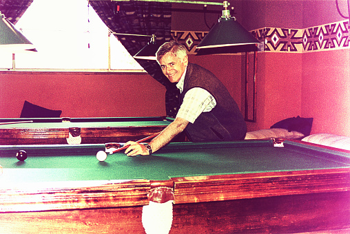 Vintage image of a senior man playing pool.