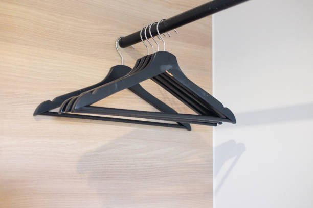 istock Empty many black plastic hanger in wood closet 1064198804