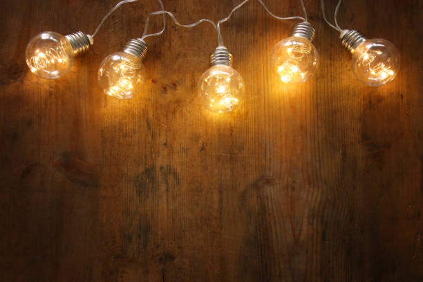 istock Christmas warm gold garland lights on wooden rustic background. 1064199668