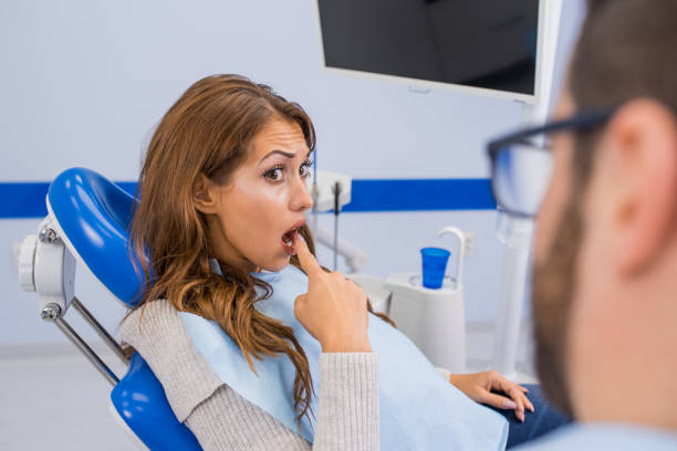 istock Young female patient talking with her dentist 1064202984