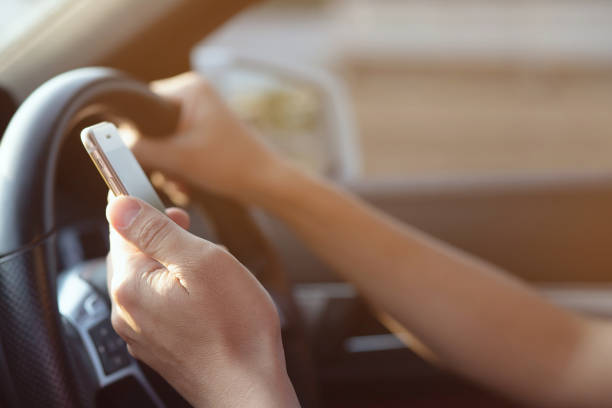 istock Young man driving using mobile smart phone while driving the car. transportation and vehicle concept 1064204784