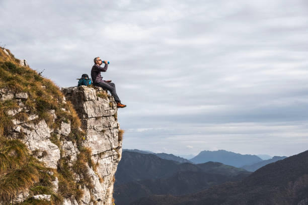 istock Hiker takes a break sitting on a rock 1064208000