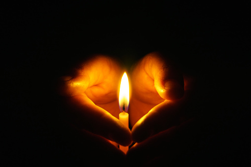La mano que protege las velas en la oscuridad. photo