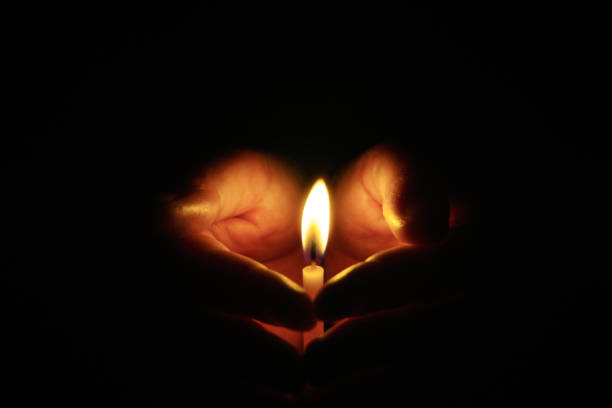 istock The hand that protects the candles in the dark. 1064209080