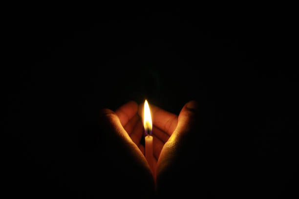 istock The hand that protects the candles in the dark. 1064209082