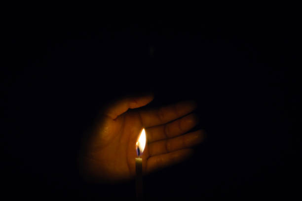 istock The hand that protects the candles in the dark. 1064209278