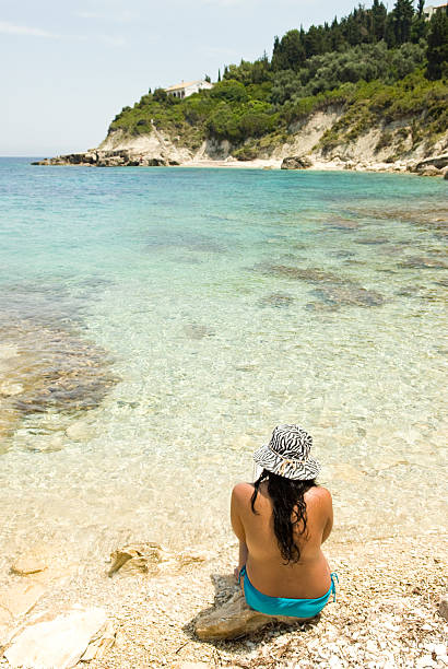 istock woman sitting on Greek beach. 106421421