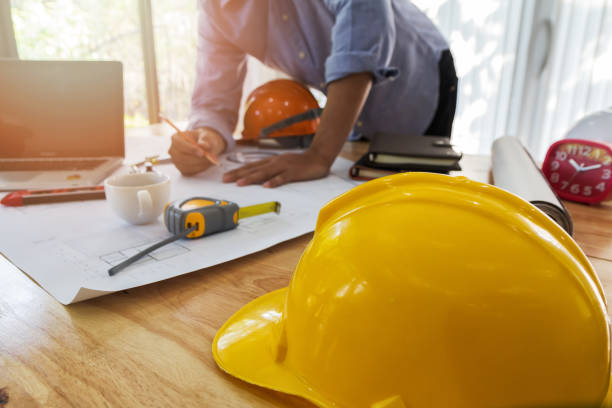 istock helmet on wooden desk with architect background 1064215320