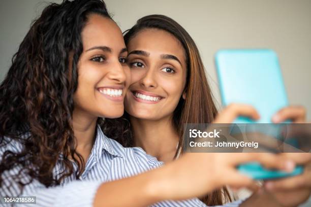 Two Young Women Taking Selfie On Phone Stock Photo - Download Image Now - Selfie, Cyborg, Friendship
