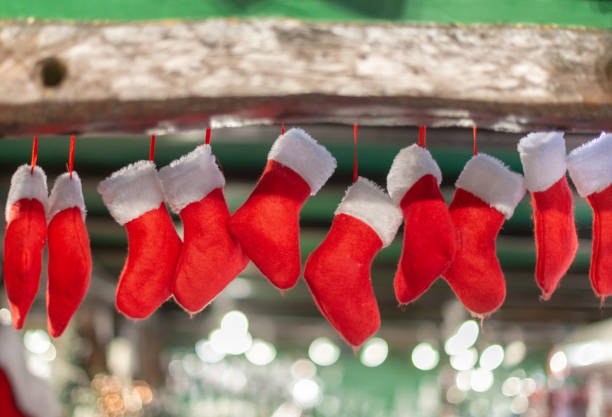 ten red and white Christmas stockings hanging from mantlepiece