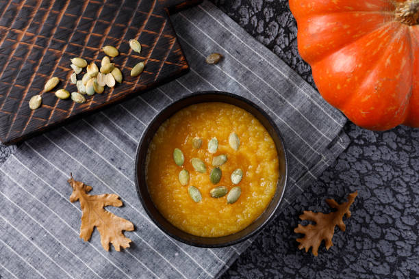 istock Pumpkin soup with pumpkin seed on dark background. 1064225284