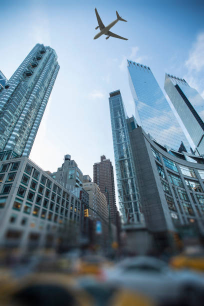 istock plane flies over the city over New York 1064225746