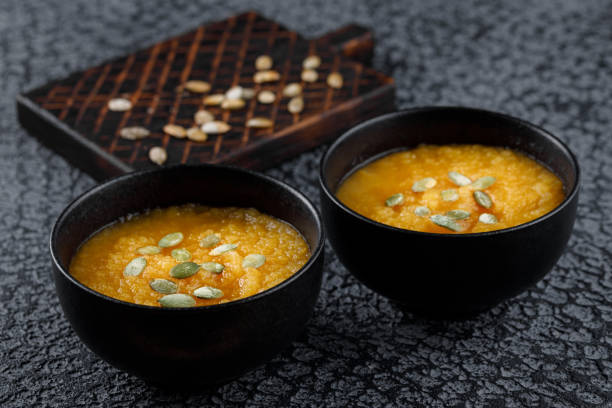 istock Roasted pumpkin soup with pumpkin seeds on dark concrete background. 1064228566
