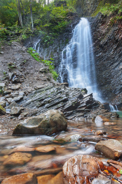 istock Long waterfall and river with rocks high in the mountains. Long exposure with blurred water. Idea for outdoor activities, travel. 1064228836