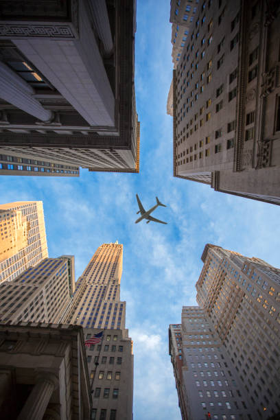 istock plane flies over the city over New York 1064229424