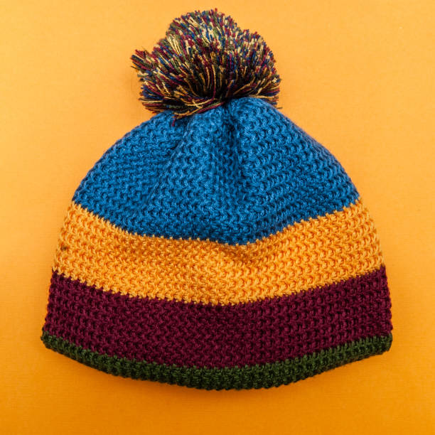 istock Knitted multicolored hat on a simple background. Minimalism, View from above, flat lay 1064232724