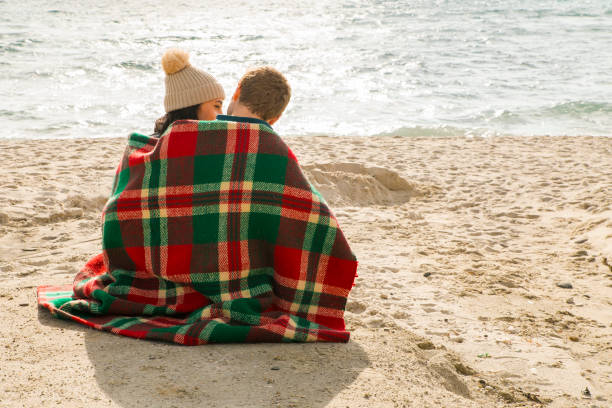 istock Young couple sitting on beach 1064233690