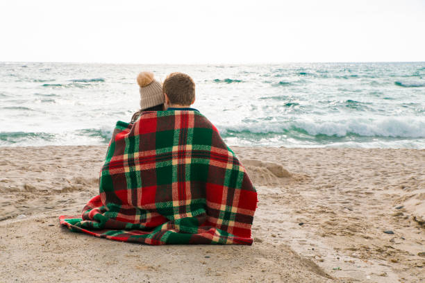 istock Young couple sitting on beach 1064235662