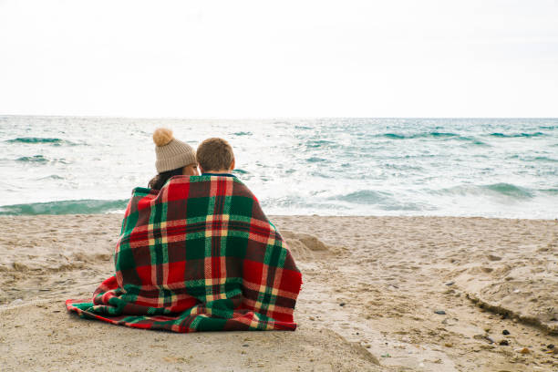 istock Young couple sitting on beach 1064236858