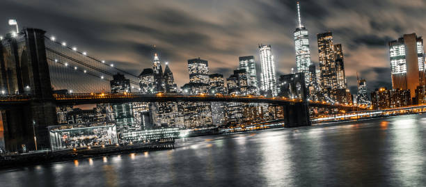 longue exposition du pont de brooklyn au cours d’une soirée bien remplie - manhattan skyline downtown district night photos et images de collection