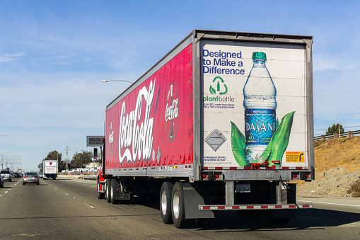 October 27, 2018 Fremont / CA / USA - Coca Cola truck driving on the freeway in East San Francisco Bay Area; Coca Cola logo printed on the side and Dasani Purified Water bottle displayed on the back