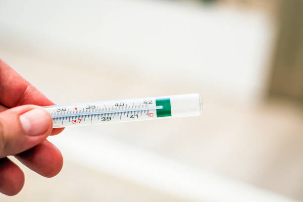 istock thermometer held by a male hand 1064244498