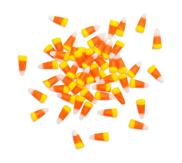 Scattered Candy Corn Scattered Pile of Candy Corn Isolated on White. candy corn stock pictures, royalty-free photos & images