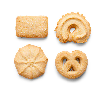 Closeup of Christmas cookie cutters on dough on a white background.