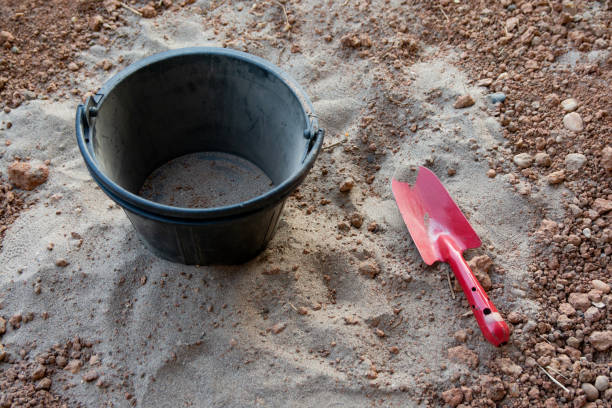 istock Red shovel and black Plastic bucket on sand 1064249424