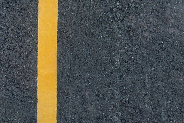 istock Yellow line on black asphalt road background with copy space 1064255062