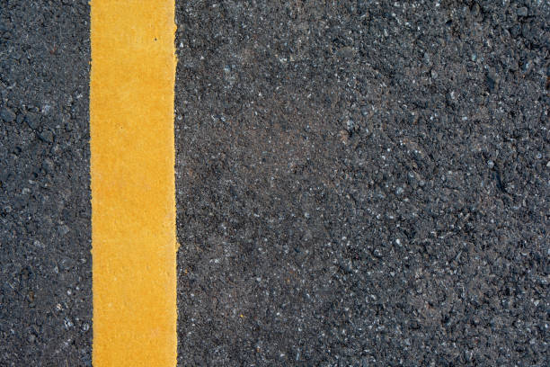 istock Yellow line on black asphalt road background with copy space 1064255370
