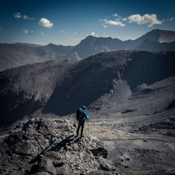 istock Anonymous mountain climber admiring view of mountains 1064261254