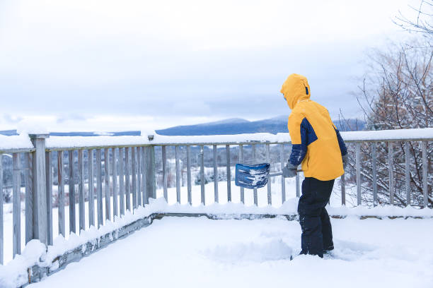 istock boy with a shovel clears snow from the porch 1064268442