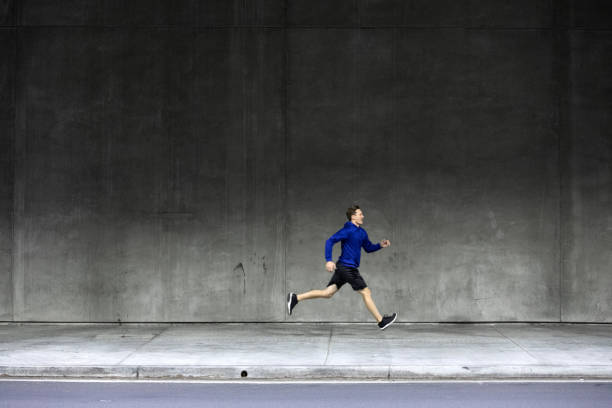 istock Athletic man running and getting fit in the city downtown after work 1064271046
