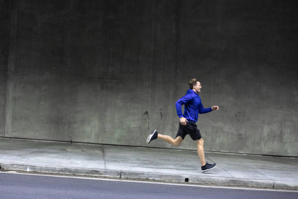 istock Athletic man running and getting fit in the city downtown after work 1064271050