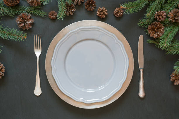 christmas table setting with silverware and dark evergreen decor. top view. holiday centerpieces. - napkin black blank ideas imagens e fotografias de stock