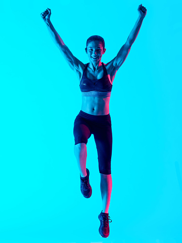 one mixed races woman exercsing fitness exercices jumping happy  isolated on blue blackground
