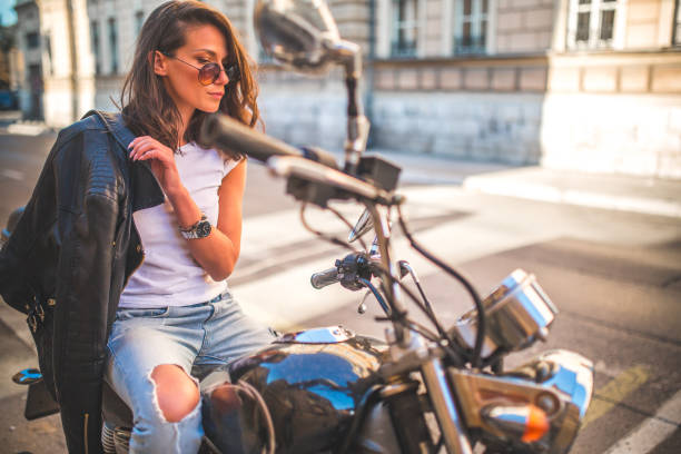 istock Young pretty fashioned girl sitting on her motorcycle 1064284854
