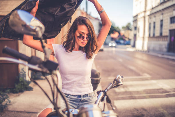 istock Young pretty fashioned girl sitting on her motorcycle 1064284964